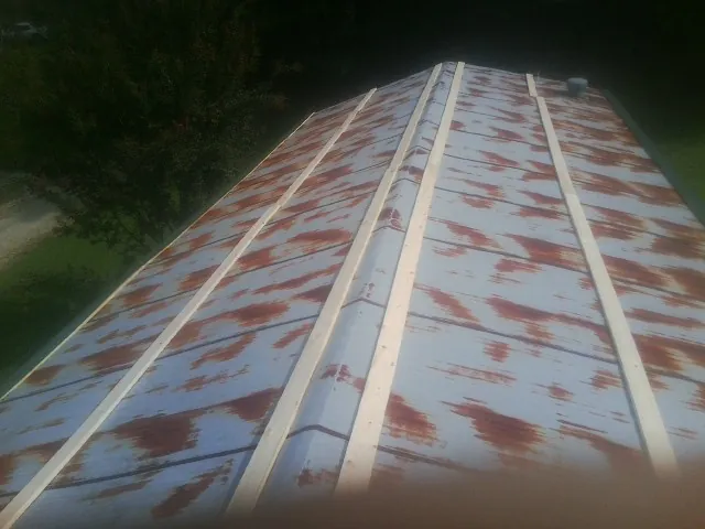 Rusted metal roof panels with new wood purlins before replacement — Storm Damage Roof Repair in Mackinaw by Roofing Brothers