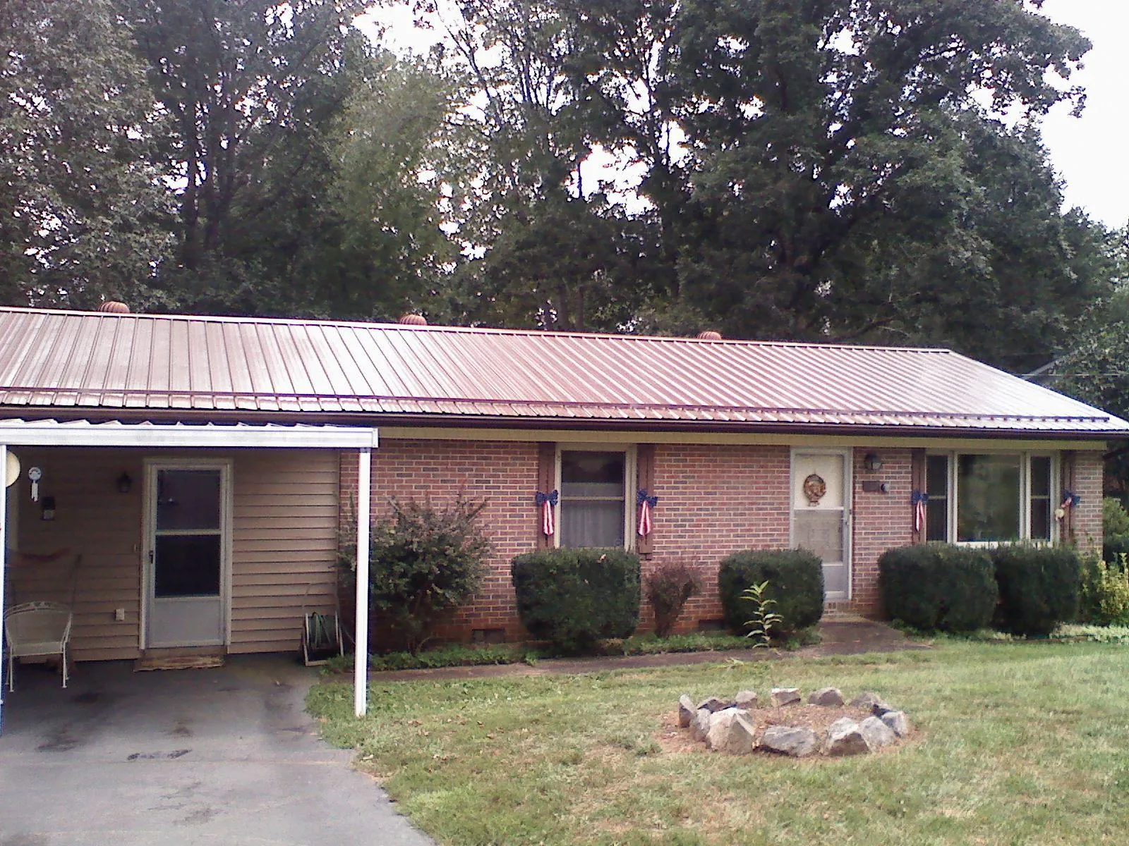 Bronze metal roof and carport on a brick ranch home — Roof Repair work by our crew in Mackinaw